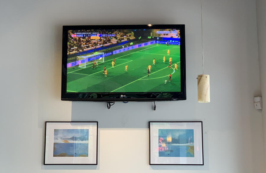 tv on wall, showing world cup soccer