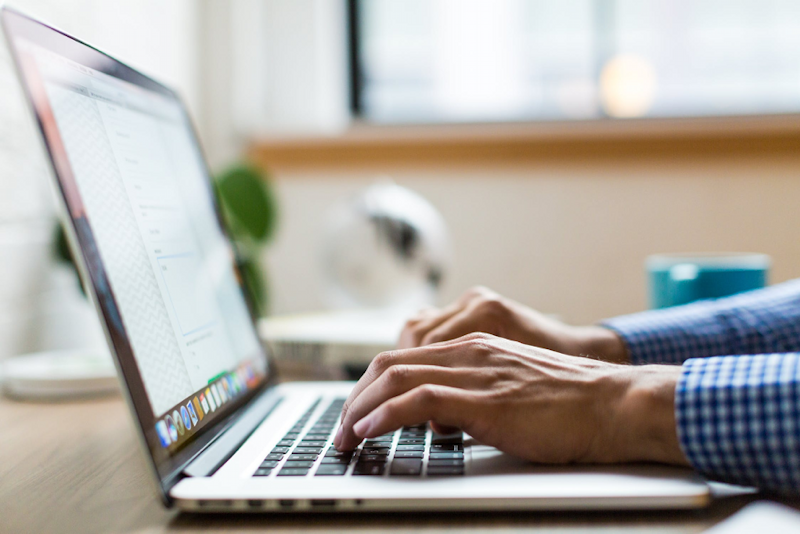 man typing on laptop hands