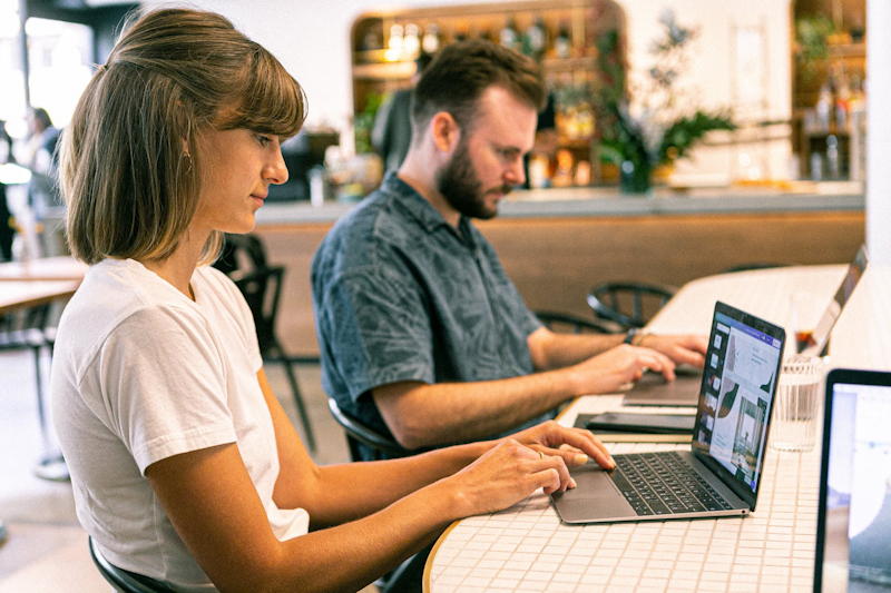 man and woman working on laptops