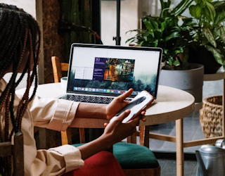 woman on phone, laptop in background