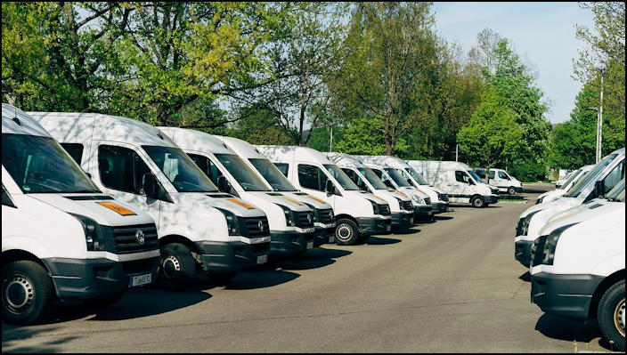 fleet of white vans in parking lot